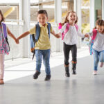 Niños saliendo del colegio sonrientes y felices